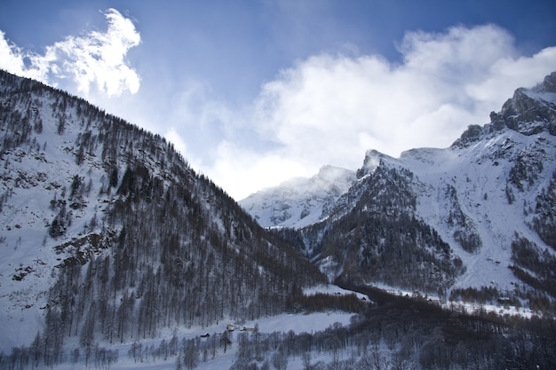 Free photo breathtaking scenery of the snow-capped mountains under a scenic cloudy sky