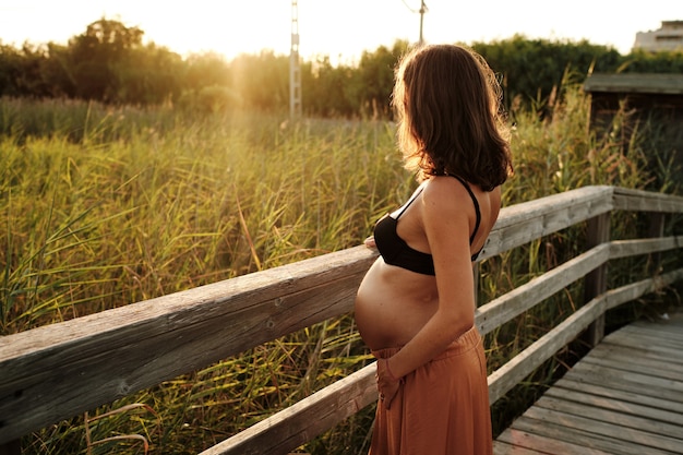 Breathtaking shot of a beautiful pregnant female posing at camera