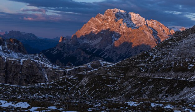 Breathtaking shot of a landscape in the Italian Alps under the cloudy sunset sky