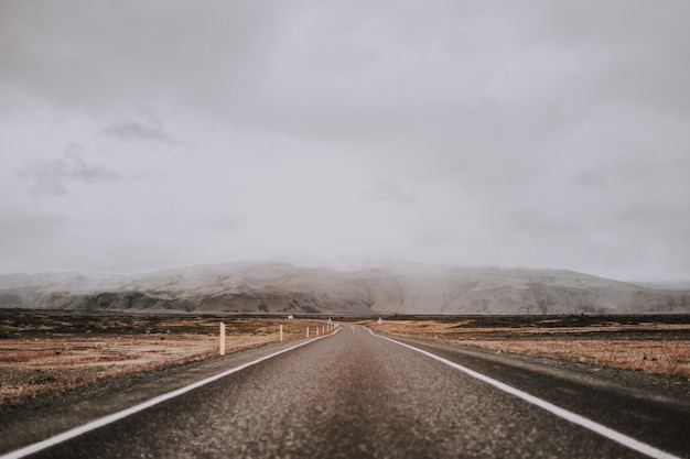 Free photo breathtaking shot of the road surrounded by amazing nature under a cloudy sky