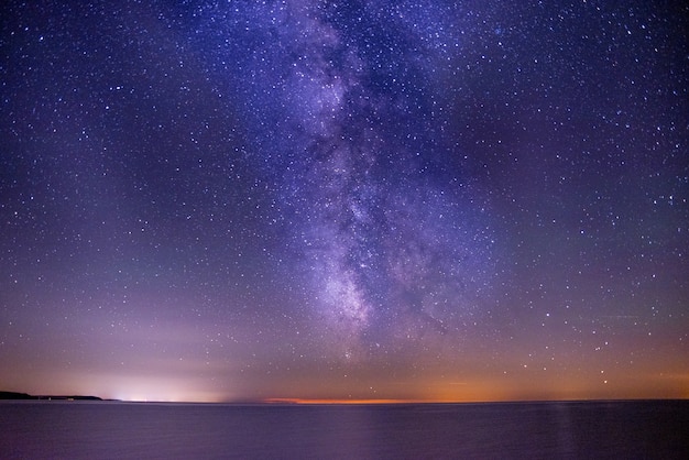 Breathtaking shot of the sea under a dark and purple sky filled with stars