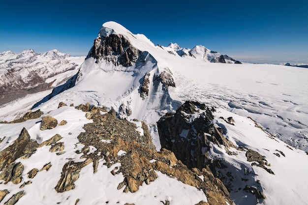 Breathtaking  shot of the snow-capped rocky mountains under a blue sky