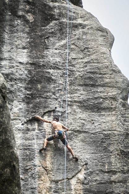 Free Photo breathtaking shot of a young male climbing on the high rock in  champfromier, france