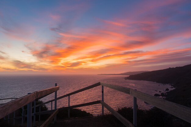 Breathtaking sunset over the calm ocean surrounded by hills