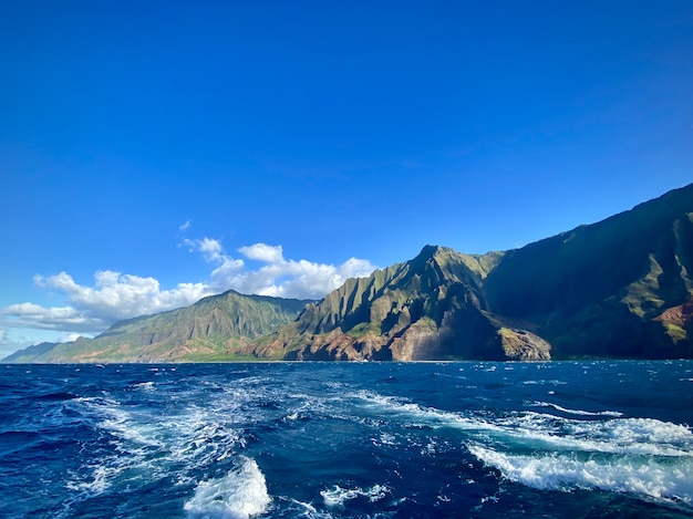 Free photo breathtaking view of the mountain cliffs over the ocean under the beautiful blue sky