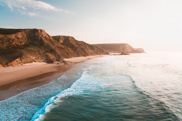 Free Photo breathtaking view of the ocean and the rocky cliffs under the beautiful bright sky