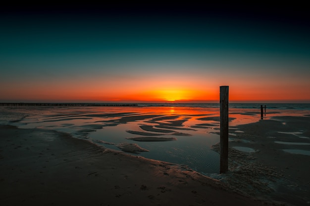 Breathtaking view of the reflection of the sunset in the ocean in Domburg, Netherlands