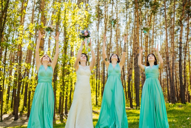 Free photo bride and bridesmaids throwing wedding bouquets.