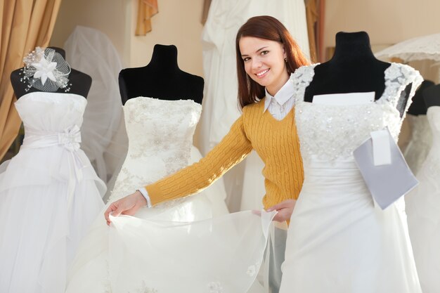 bride chooses wedding gown at bridal boutique