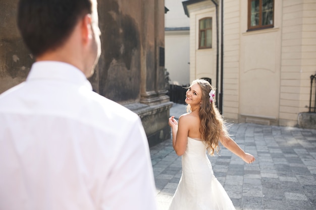 Free Photo bride dancing in the street while her husband watches