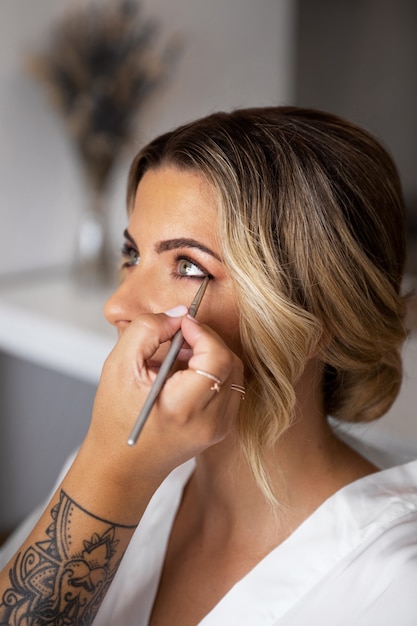 Bride getting makeup ready for wedding side view