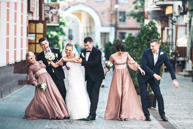 Free photo bride groom groomsmen bridesmaids dancing on street