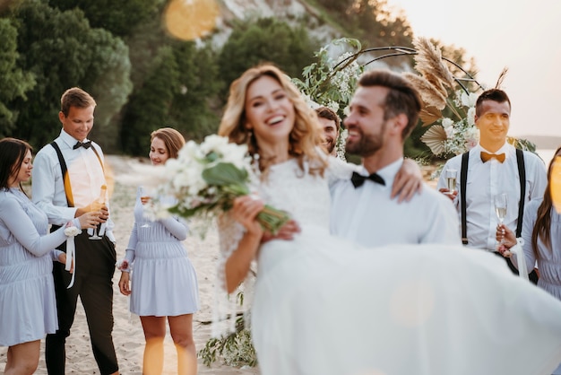 Free photo bride and groom having their wedding with guests on a beach