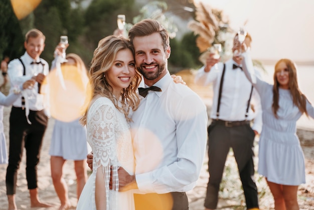 Free photo bride and groom having their wedding with guests on a beach