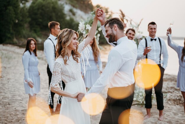 Bride and groom having their wedding with guests on a beach