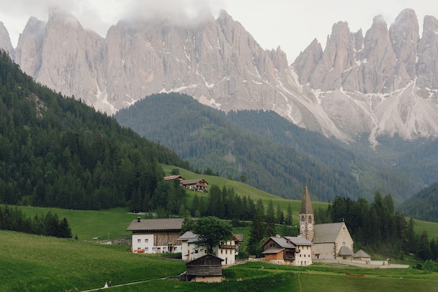 Free Photo bride and groom hold each other hands walking to the church somewhere in italian dolomites 