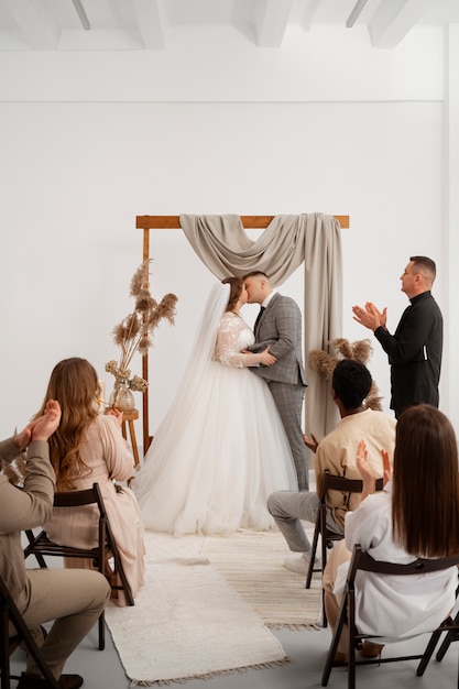 Free photo bride and groom kissing during wedding ceremony