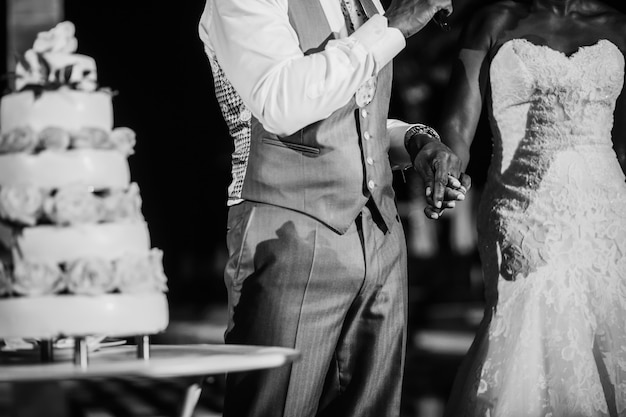 Bride and groom ready to cut classic white wedding cake