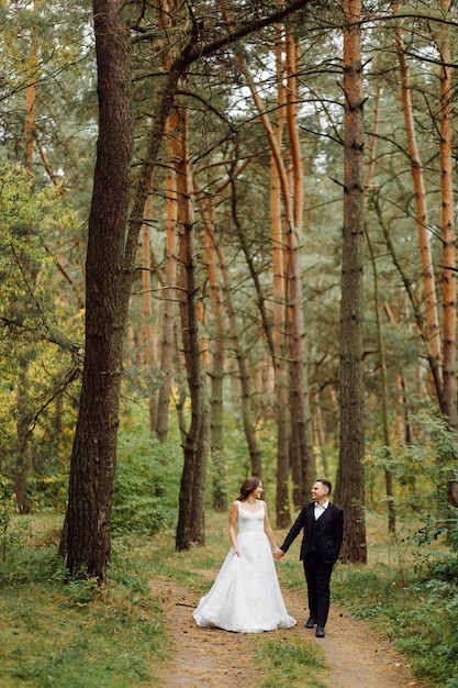 The bride and groom run through a forest Wedding photo shoot