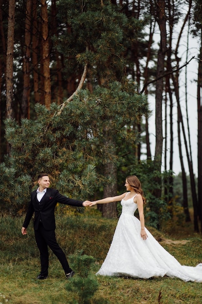 The bride and groom run through a forest Wedding photo shoot