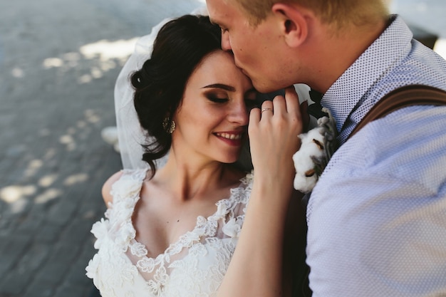 Bride and groom sit on the bench and having fun