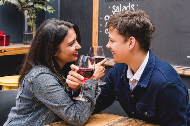 Free photo bride and groom smiling while crossing their arms with glasses of wine