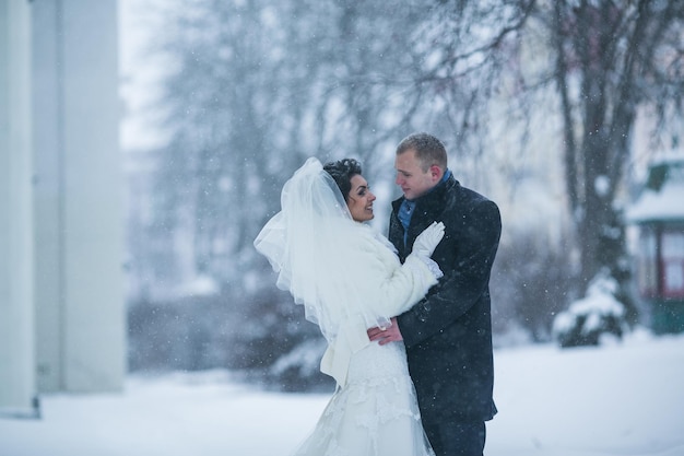 Bride and groom walking on the European city in the snow