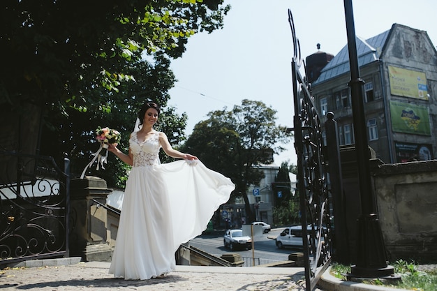 Free Photo bride holding the bouquet and showing dress