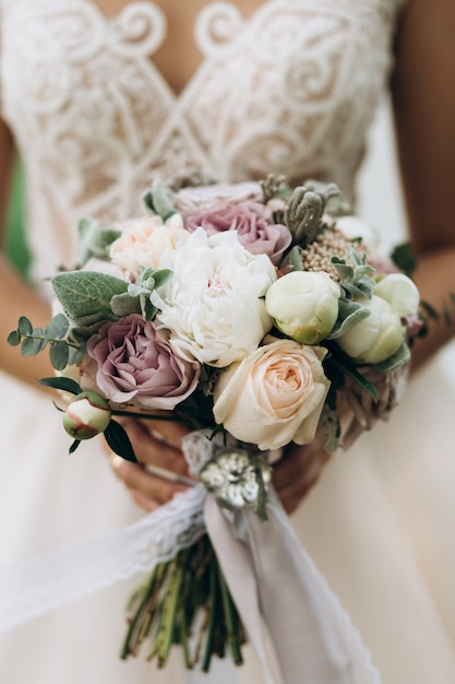 Bride holds the beautiful bridal bouquet, close up