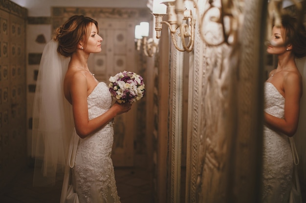 Free photo bride looking in the mirror