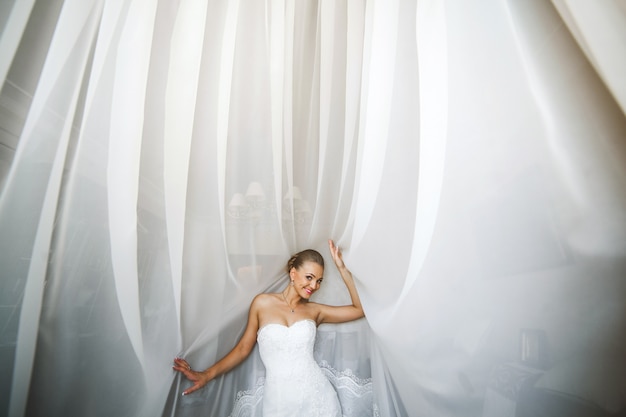 Free photo bride posing with white curtains