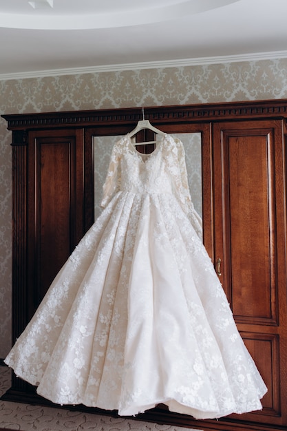 Bride's dress hangs on a wardrobe