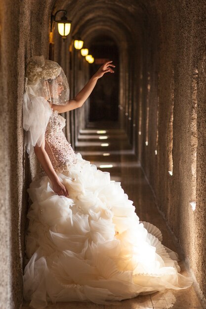 Bride next to the wal with raised hand