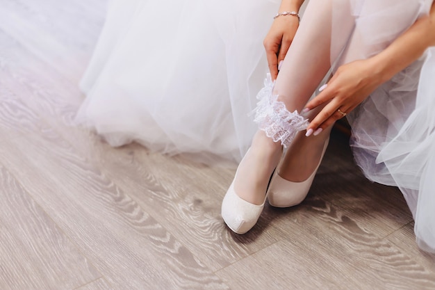 Free photo the bride wears shoes on a wedding morning