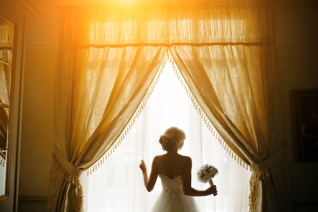 Free Photo bride with bouquet next to the window