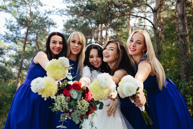 Bride with bridesmaids holding bouquets posing