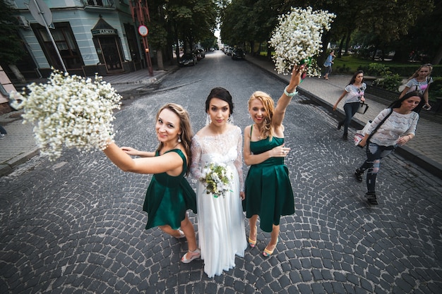 Free photo bride with friends holding bouquets