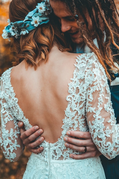 Free photo bride with wedding dress hugging groom