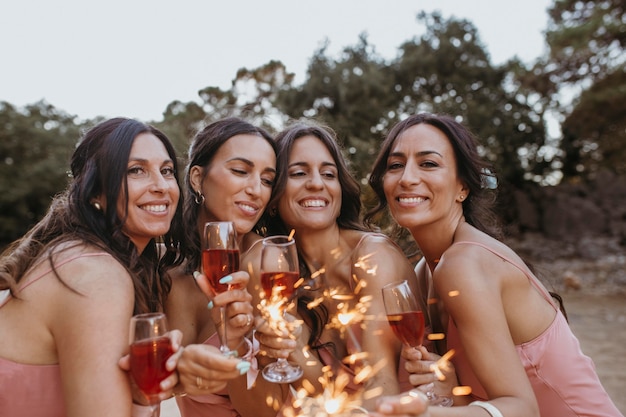 Bridesmaids in pretty dresses celebrating the wedding outdoors