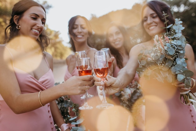 Bridesmaids in pretty dresses celebrating the wedding outdoors