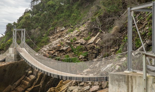 Bridge made of wood and metal going around the mountain