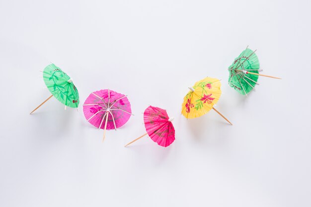 Bright cocktail umbrellas on white table