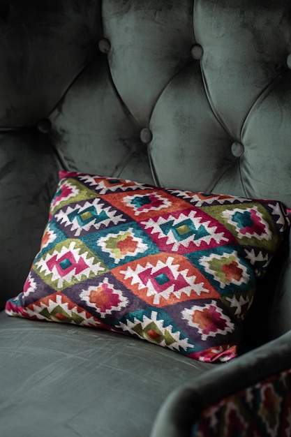 Free Photo a bright decorative pillow with a geometric design on a green armchair