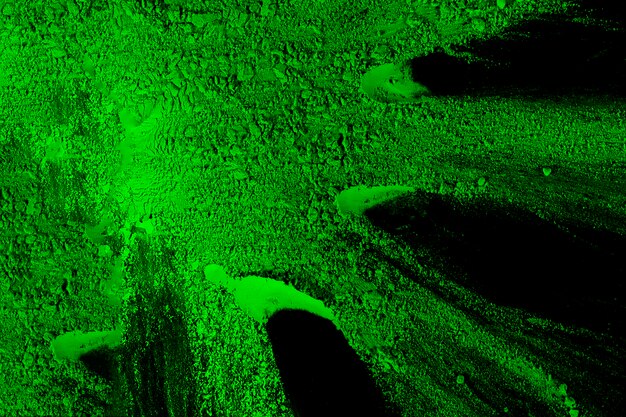 Bright green holi powder over black background