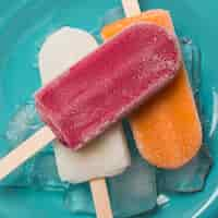 Free photo bright ice lolly on plate with ice