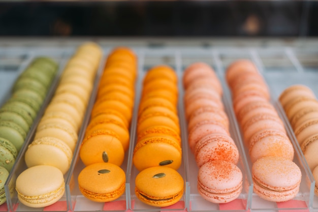 Free photo bright macaroons on display case in cafe