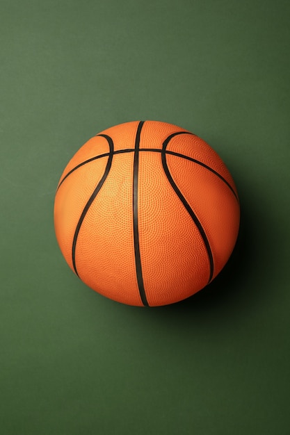 Bright orange-braun basketball ball. Professional sport equipment isolated on green background.