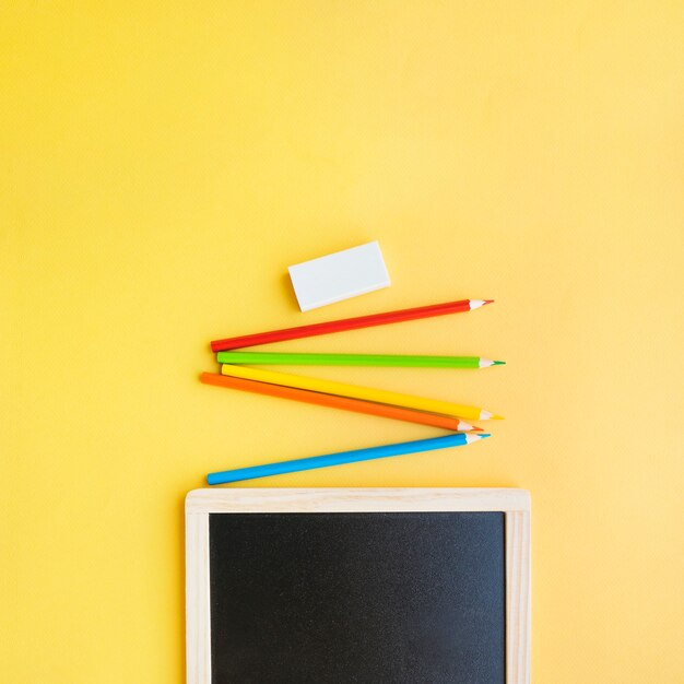 Bright pencils and rubber near blackboard