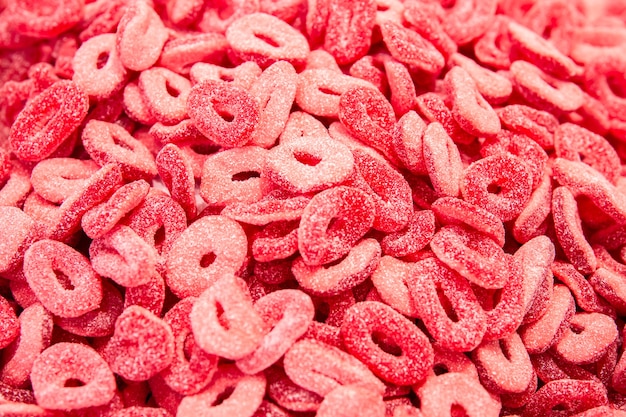 Bright red background with curly gummy gummy sweets