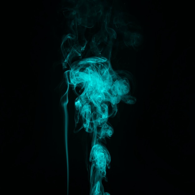 Free Photo bright turquoise smoke trail abstract black background